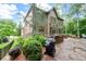 Exterior elevation showcasing a well-manicured backyard with a stone patio, and mature landscaping at 2239 Tayside Nw Xing, Kennesaw, GA 30152