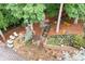 Stone patio with seating, retaining wall, lush greenery, and shade trees creating a private outdoor oasis perfect for relaxation at 2239 Tayside Nw Xing, Kennesaw, GA 30152