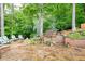 Stone patio with outdoor seating, manicured landscaping, and mature trees provides a peaceful retreat at 2239 Tayside Nw Xing, Kennesaw, GA 30152