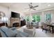 Bright living room with stone fireplace, ceiling fan, modern decor, and lots of natural light at 2239 Tayside Nw Xing, Kennesaw, GA 30152