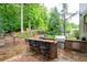 Backyard with an outdoor kitchen, built-in grill, bar seating, and lush greenery is perfect for entertaining at 2239 Tayside Nw Xing, Kennesaw, GA 30152