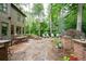 Stone patio with an outdoor table, fire pit, outdoor chairs, and lush greenery create an inviting space at 2239 Tayside Nw Xing, Kennesaw, GA 30152