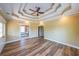 This bedroom includes a decorative tray ceiling and wood-look floors, offering a view to the bath at 3416 Harrison Rd, Atlanta, GA 30344