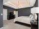 Stylish main bedroom featuring dark walls, carpet floors, a tray ceiling, and a modern chandelier at 1580 Johnson Nw Rd, Atlanta, GA 30318