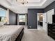 A spacious main bedroom with dark walls, carpet, tray ceiling, and a door leading to the bathroom at 1580 Johnson Nw Rd, Atlanta, GA 30318