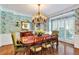 Elegant dining room featuring beautiful wallpaper, a grand chandelier, and ample natural light at 2250 Edgemere Lake Cir, Marietta, GA 30062