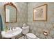 Charming powder room featuring designer wallpaper, a framed mirror, a pedestal sink, and classic fixtures at 2250 Edgemere Lake Cir, Marietta, GA 30062