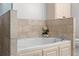 Close up on the soaking tub in the primary bath which features white cabinets and stone-look tile at 2255 Peachtree Ne Rd # 521, Atlanta, GA 30309