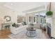 Elegant living room boasting a decorative fireplace, tray ceiling, and large windows for natural light at 309 Sassafras Way, Holly Springs, GA 30115