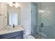 A bathroom featuring a vanity with a sink, a toilet, and a glass-door shower with tile and silver fixtures at 3440 Carswell Bnd, Cumming, GA 30028