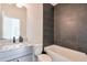 Modern bathroom featuring stylish gray tile accents, a granite countertop, and a sleek, updated design at 3440 Carswell Bnd, Cumming, GA 30028