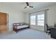 A bedroom featuring carpeted floors, a ceiling fan, a daybed, and two windows for ample natural light and neighborhood views at 3440 Carswell Bnd, Cumming, GA 30028