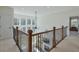 Bright upstairs hallway with hardwood railing and views of the living room and backyard at 3440 Carswell Bnd, Cumming, GA 30028