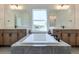 A main bathroom with double vanities, a drop-in bathtub, tiled floors, and a window with natural light at 3440 Carswell Bnd, Cumming, GA 30028