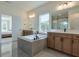 A main bathroom with double vanities, a drop-in bathtub, a glass-door shower, and tiled floors at 3440 Carswell Bnd, Cumming, GA 30028