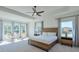 Bright main bedroom with a ceiling fan, tray ceiling, carpeted floors, and natural light from large windows with views at 3440 Carswell Bnd, Cumming, GA 30028