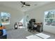 Bright office space with modern fan, two windows, and a work desk bathed in natural light at 3440 Carswell Bnd, Cumming, GA 30028