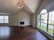 Bright living room with a fireplace, hardwood floors, and large windows overlooking the yard at 1015 Crest Ridge Sw Pl, Marietta, GA 30060