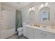 Bright bathroom featuring a double sink vanity, shower with curtain, and ample lighting at 1240 Kilmington Ct, Alpharetta, GA 30009