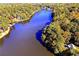 Stunning aerial view of a lake surrounded by lush, mature trees and foliage in the autumn at 2075 Six Branches, Roswell, GA 30076