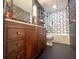 Bathroom features designer vanity, patterned wallpaper, and shower-over-tub with grid tile surround at 2075 Six Branches, Roswell, GA 30076