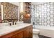 A stylish bathroom featuring a granite counter vanity, floral wallpaper, and tiled shower at 2075 Six Branches, Roswell, GA 30076