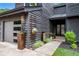 Modern home entrance with gray wood siding, black framed windows, and stylish flower planters at 2075 Six Branches, Roswell, GA 30076
