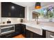 Modern kitchen featuring black cabinets, stainless steel appliances, and a farmhouse sink at 2075 Six Branches, Roswell, GA 30076