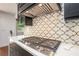 Modern kitchen featuring stainless steel cooktop and decorative backsplash at 2075 Six Branches, Roswell, GA 30076