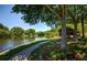 Scenic view of a paved path beside a tranquil lake with trees and benches nearby at 2075 Six Branches, Roswell, GA 30076