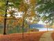 Tranquil lakeside view with trees in autumn colors and a paved path at 2075 Six Branches, Roswell, GA 30076