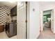 A practical laundry room features patterned wallpaper, washer/dryer, and storage cabinets at 2075 Six Branches, Roswell, GA 30076