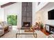 Comfortable living room featuring a fireplace, hardwood floors, and plenty of natural light at 2075 Six Branches, Roswell, GA 30076