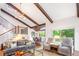Living room features high ceilings, exposed beams, staircase, and large windows with picturesque views at 2075 Six Branches, Roswell, GA 30076