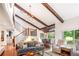 Open living room featuring vaulted ceilings, wood beams, hardwood floors, a staircase, and a gray sofa at 2075 Six Branches, Roswell, GA 30076
