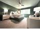 A primary bedroom showcases soothing green walls, a large window, and cozy sitting area at 2075 Six Branches, Roswell, GA 30076