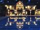 Stunning pool reflects the home at night, creating an inviting outdoor oasis for relaxation and memorable evenings at 2075 Six Branches, Roswell, GA 30076