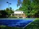 Community clubhouse and tennis court surrounded by lush trees and greenery at 2075 Six Branches, Roswell, GA 30076