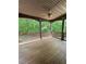 Inviting covered back porch with wood flooring, ceiling fan, and wooded backyard view at 3400 Suwanee Creek Rd, Suwanee, GA 30024