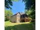Expansive backyard showcasing a brick home, covered deck, and open space at 3400 Suwanee Creek Rd, Suwanee, GA 30024