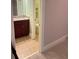 Hallway view of bathroom with single sink vanity, ceramic tile floors, toilet, and decor at 3400 Suwanee Creek Rd, Suwanee, GA 30024