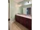 Well-lit bathroom with double sinks, granite countertops, dark wood cabinets, and ceramic tile flooring at 3400 Suwanee Creek Rd, Suwanee, GA 30024