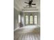 Large bedroom featuring tray ceiling, three windows, neutral carpet and ceiling fan with light fixture at 3400 Suwanee Creek Rd, Suwanee, GA 30024