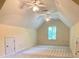 Spacious bonus room with vaulted ceiling, carpet floors, two ceiling fans, and a bright window at 3400 Suwanee Creek Rd, Suwanee, GA 30024