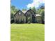 Charming brick home featuring a manicured lawn and lush landscaping at 3400 Suwanee Creek Rd, Suwanee, GA 30024