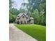 Beautiful brick home featuring a well-maintained lawn and mature trees at 3400 Suwanee Creek Rd, Suwanee, GA 30024