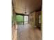 Large covered porch featuring a wood floor, brick wall, ceiling fan, and relaxing wooded views at 3400 Suwanee Creek Rd, Suwanee, GA 30024