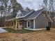 Home exterior featuring a covered porch, rocking chairs, and gravel driveway at 40 Luther Knight Se Rd, Cartersville, GA 30121