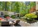 An outdoor living space features a patio with seating, a dining table, and beautiful landscaping at 2890 Howell Mill Rd, Atlanta, GA 30327