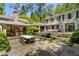 Charming backyard with an outdoor fireplace, dining area, and landscaped garden at 2890 Howell Mill Rd, Atlanta, GA 30327